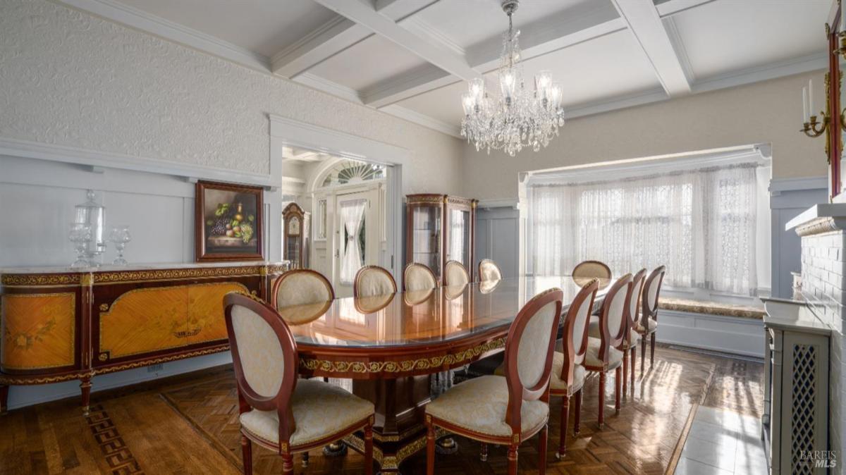 Dining room with a long table and a chandelier.