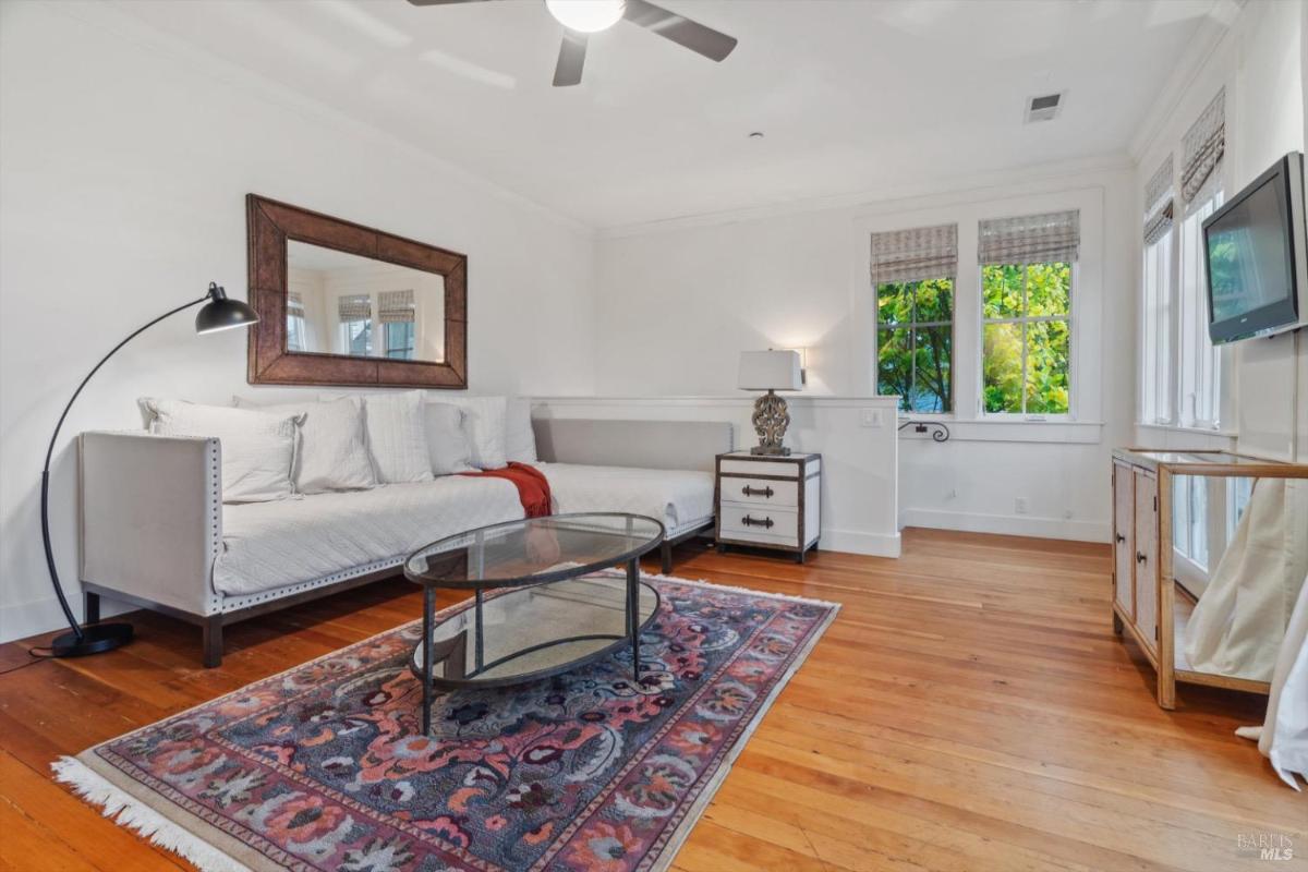 A family room with a sofa, chairs, a coffee table, and a mounted television.