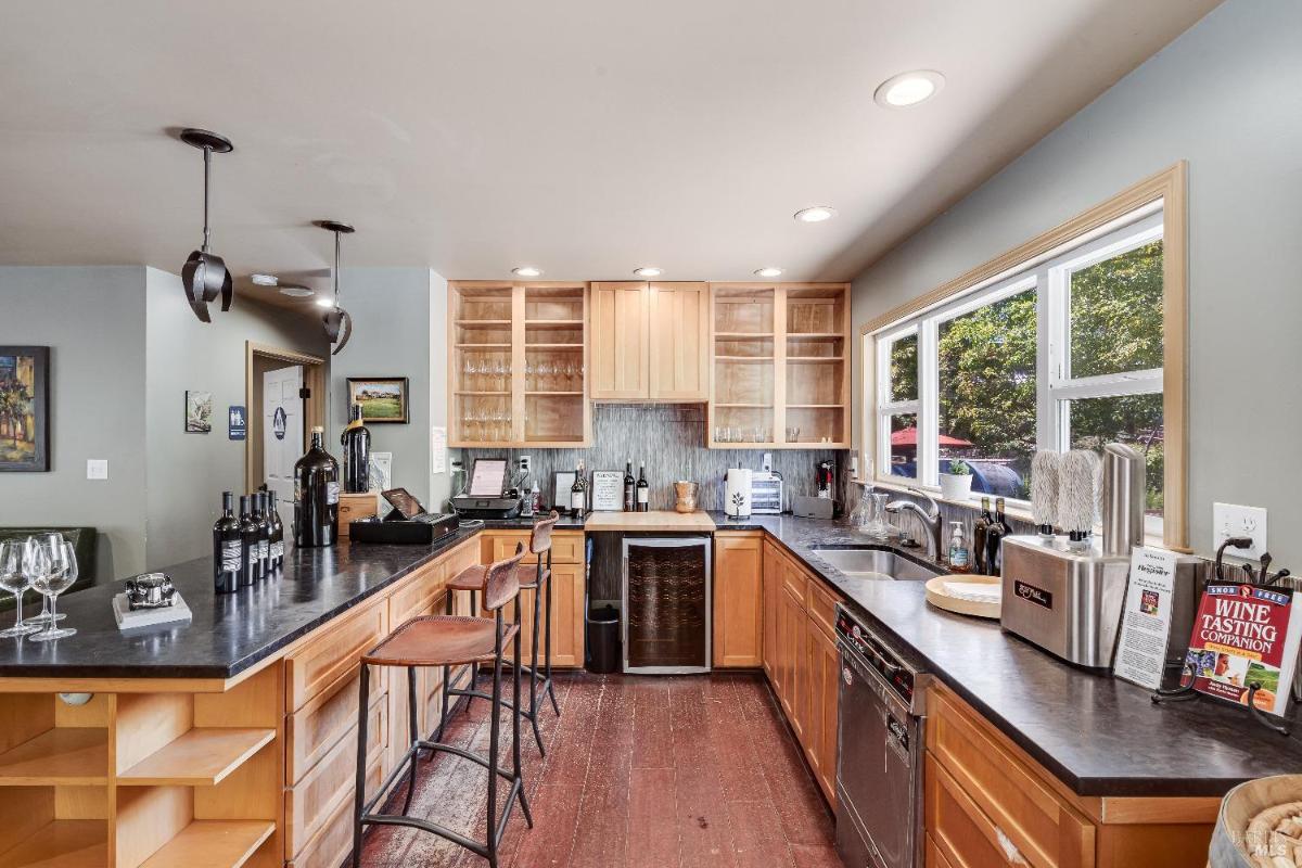 Bar area with countertops, wooden cabinets, and wine storage.