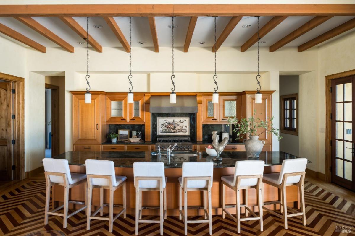 Kitchen with a large island, bar seating, and wood cabinetry.