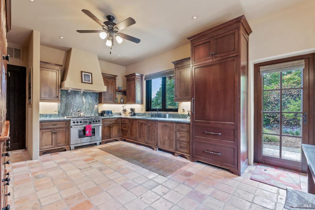 Kitchen with tiled floors, dark wood cabinets, and a large oven range.