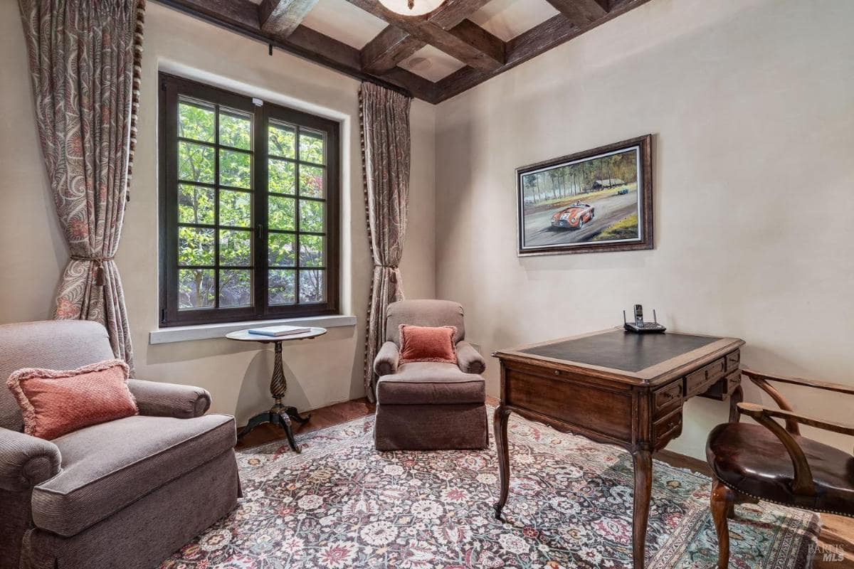 Study room with two armchairs, a desk, and a window.