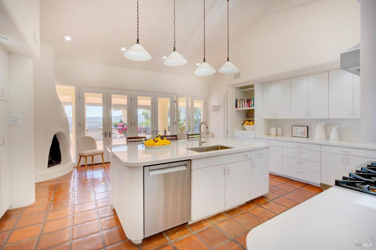 A kitchen with an island and glass doors leading to the patio.