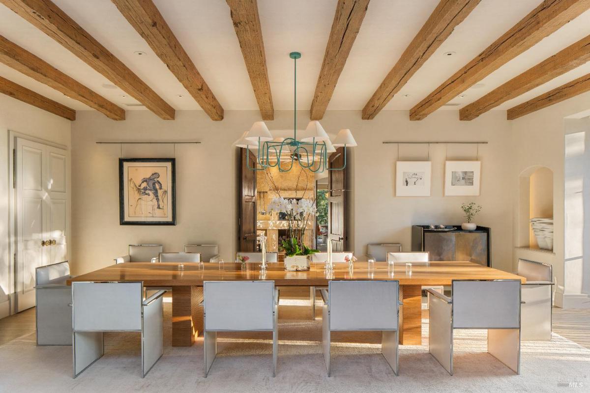 Dining room with exposed wooden beams and seating for twelve.