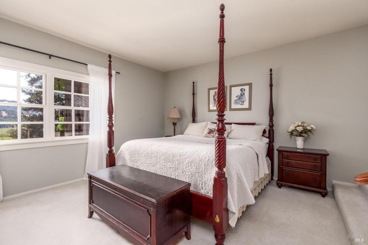 Bedroom with a four-poster bed, side tables, and a window.