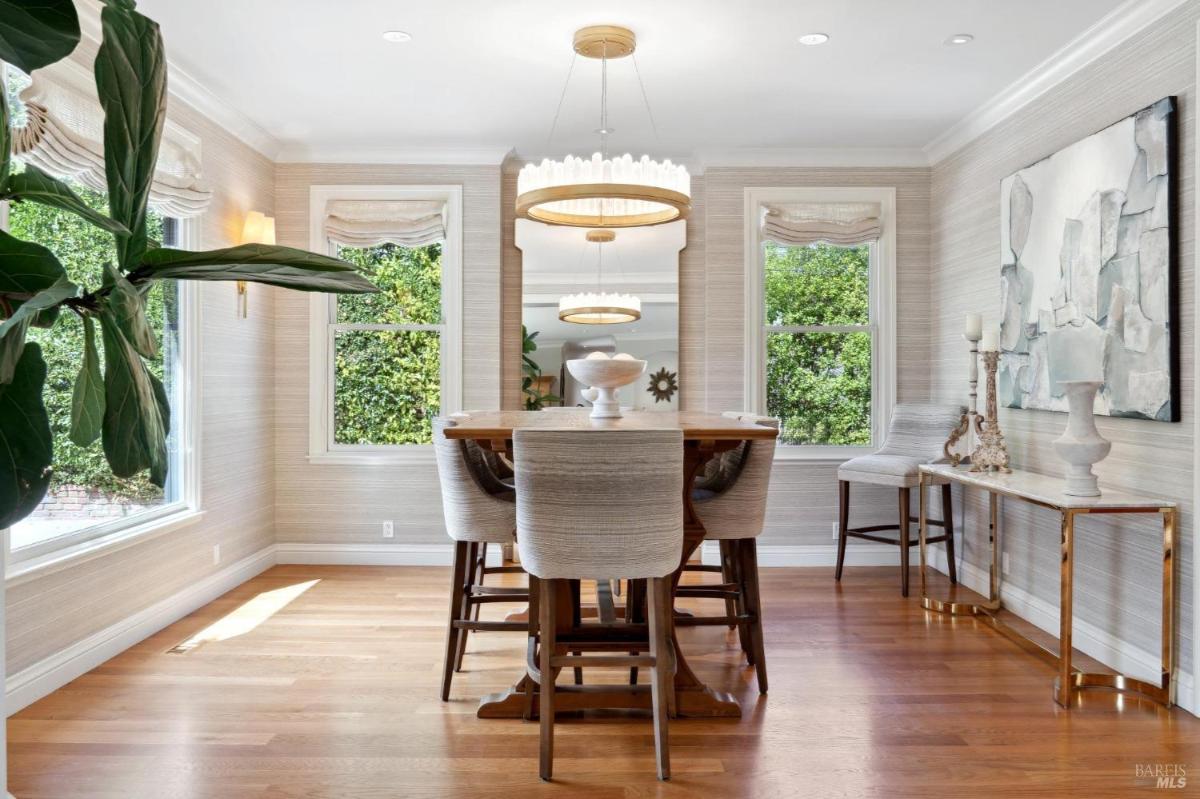 Dining room with a rectangular table, chairs, and large windows.