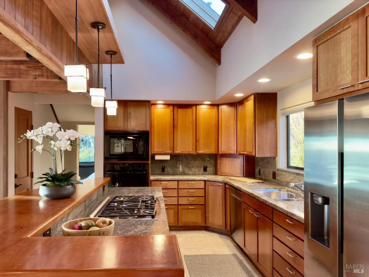 Kitchen with appliances and wood-paneled ceilings.