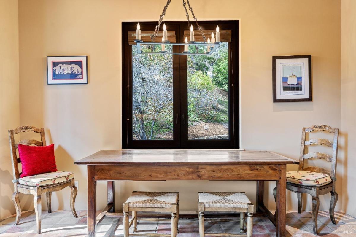 A sitting area with a wooden table, chairs, and a window view.