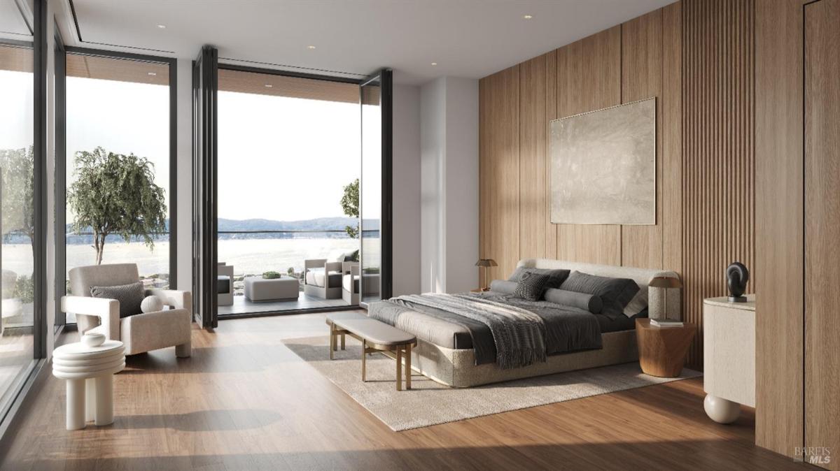 Modern bedroom featuring warm wood accents and large glass doors that open to outdoor space. 