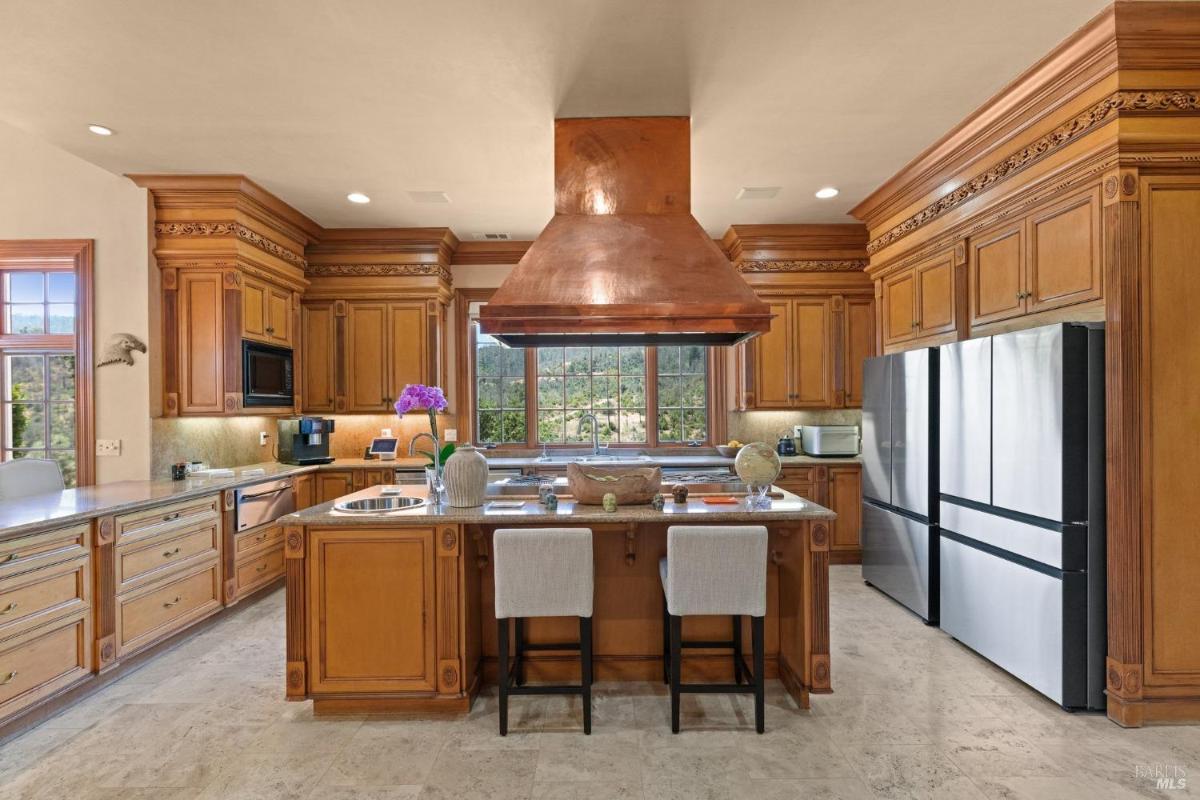 A kitchen layout with a large counter bar, built-in display cabinets, and ample storage.