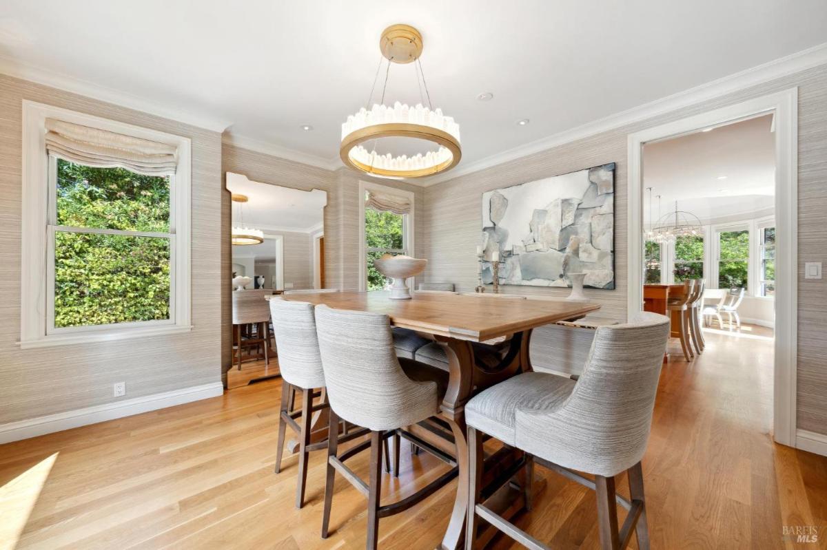 Dining room with a rectangular table, chairs, and large windows.