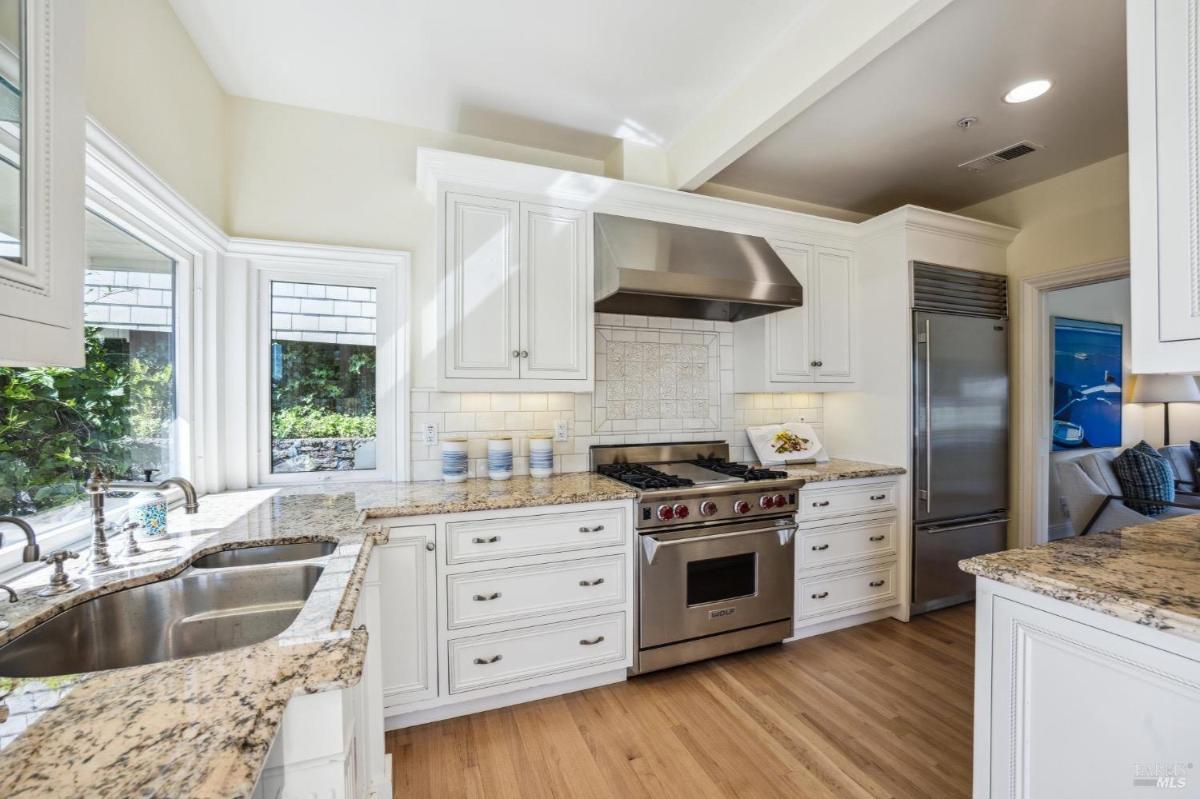 Kitchen with a large stove, white cabinetry, and stainless steel appliances.