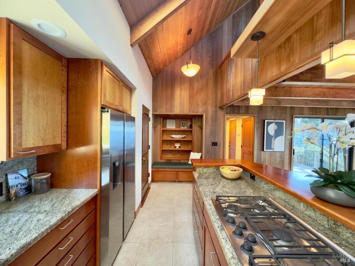 Kitchen with appliances and wood-paneled ceilings.