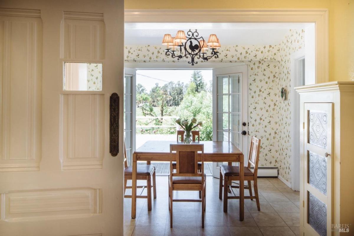 Breakfast area with a table, chairs, and glass doors leading outside.