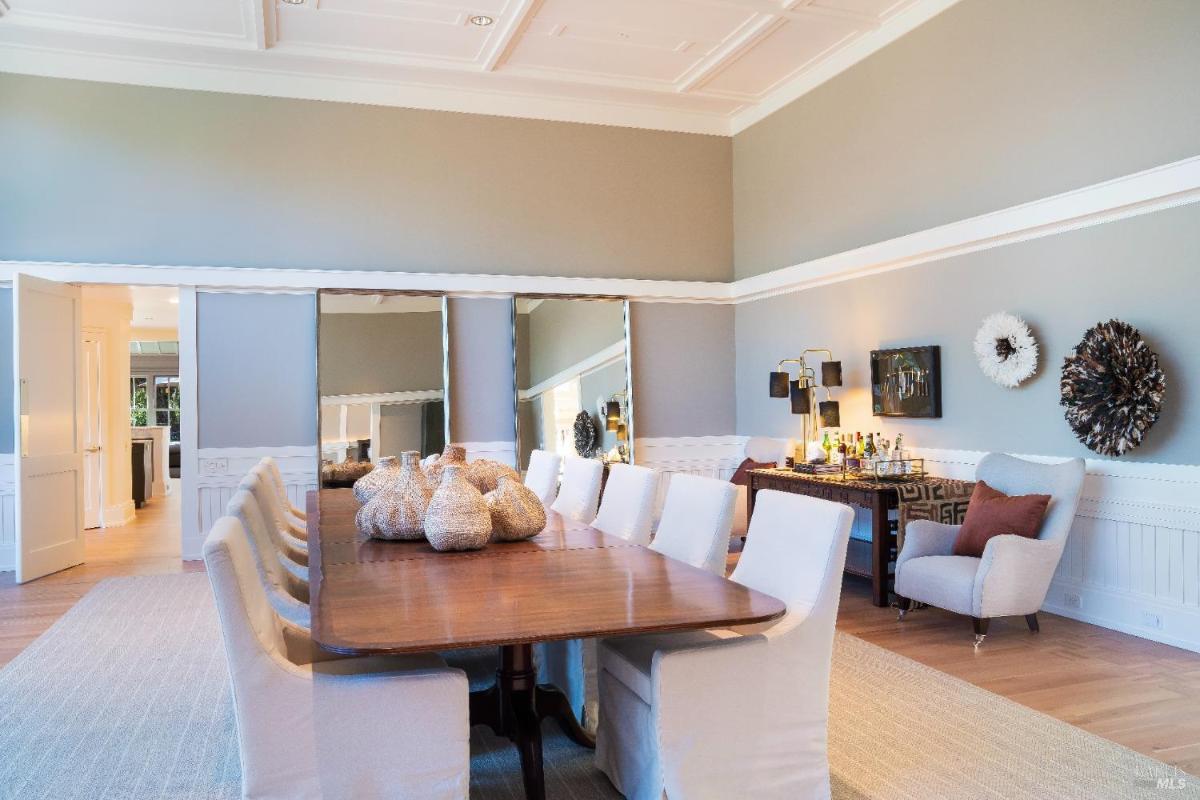 Dining area with a sideboard, decorative mirrors, and a bar setup.