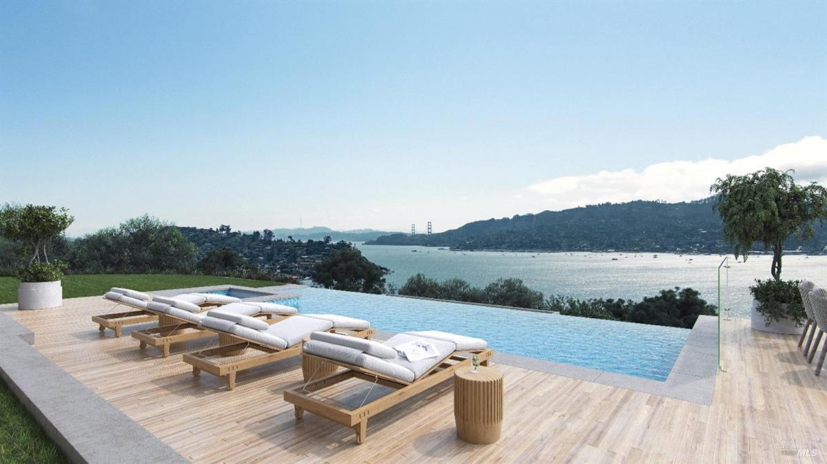 Pool area with a stunning view of a body of water and surrounding hills. 