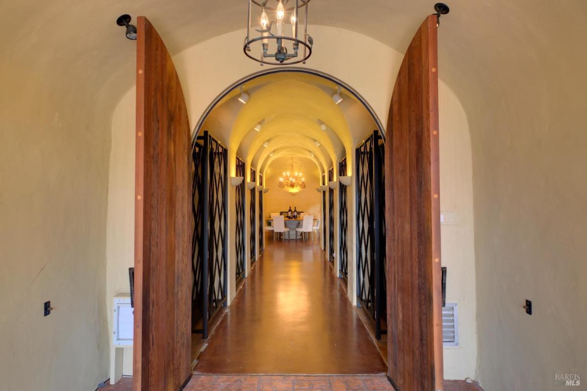 A hallway featuring arched ceilings and decorative doors on either side.