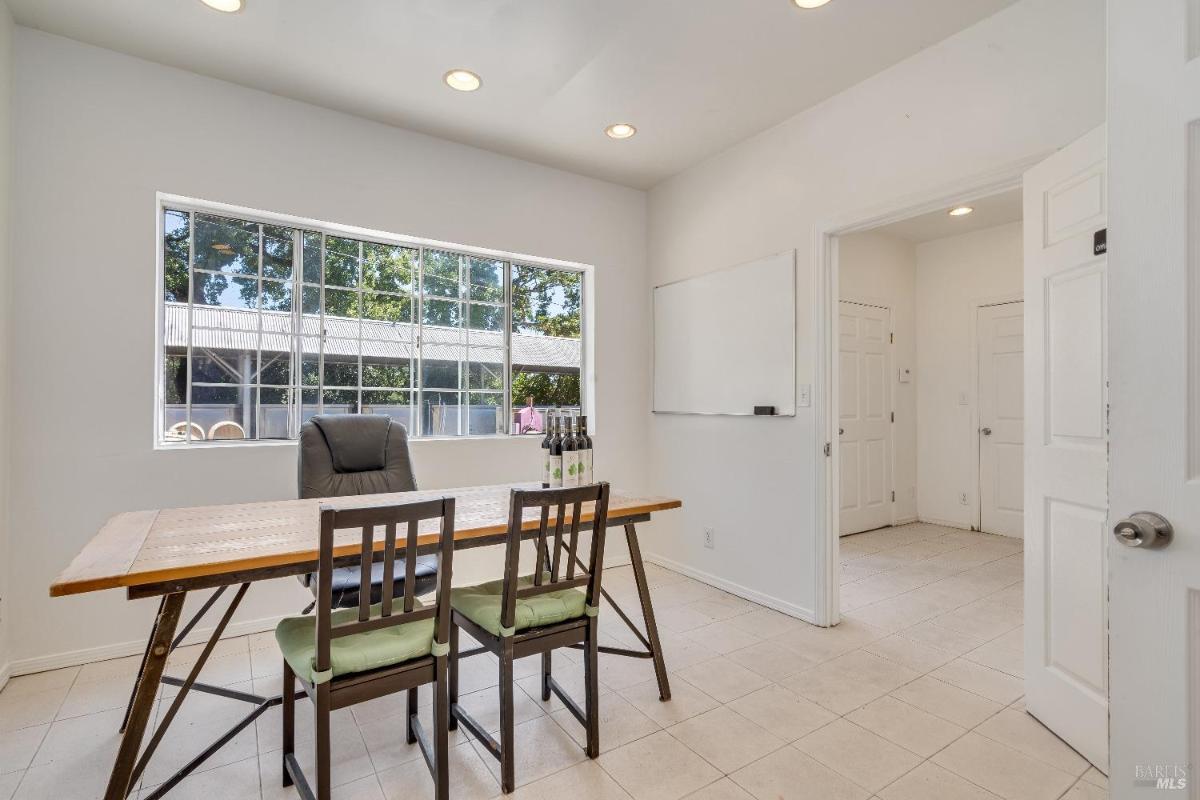 Office space with a wooden table, chairs, and a large window.