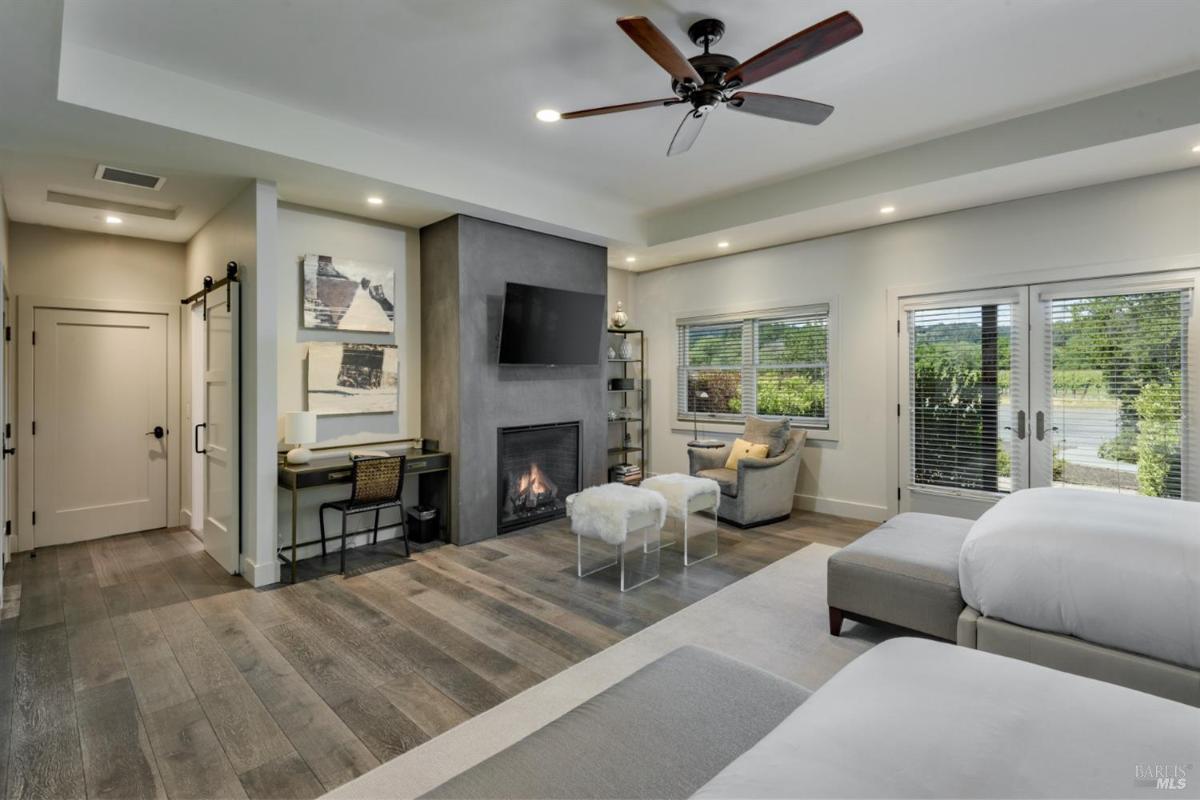 Double bedroom with a fireplace, desk, and sliding barn door.