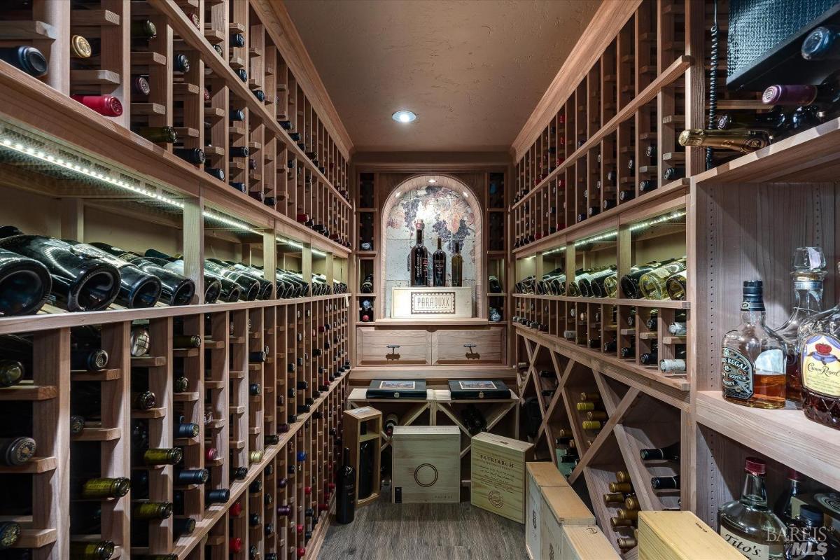 A wine cellar with shelves filled with wine bottles and a display area.