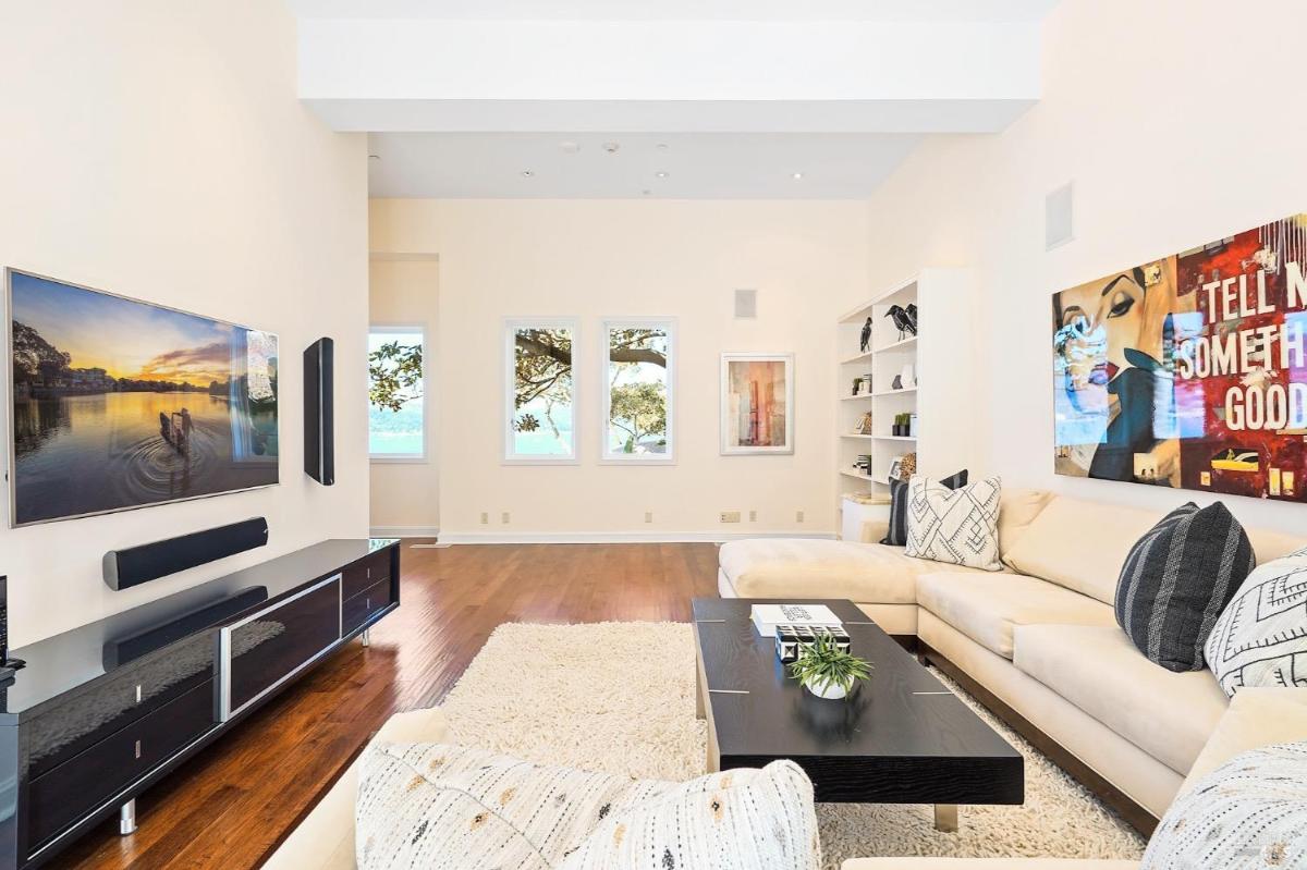 Family room with a sectional sofa, mounted TV, and modern artwork on the walls.