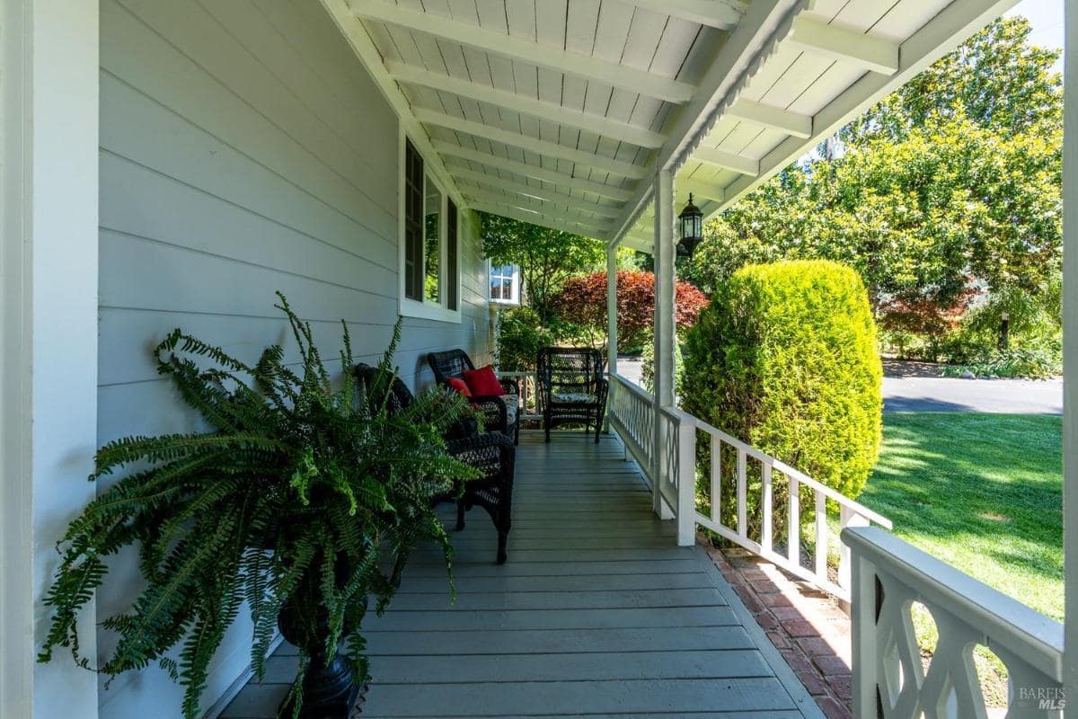 Front porch with seating and a railing.