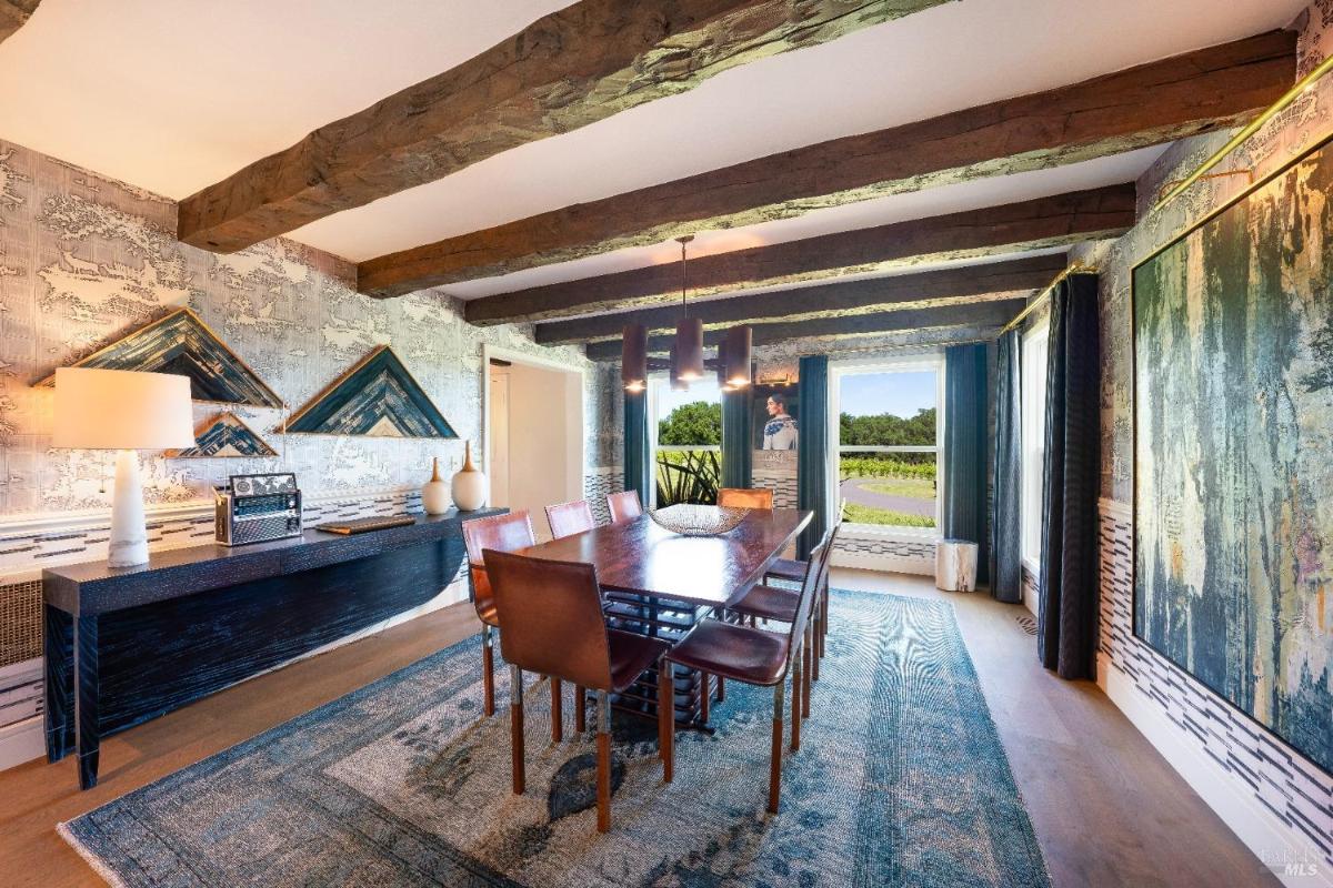 Side view of the dining area with large windows overlooking the vineyard.