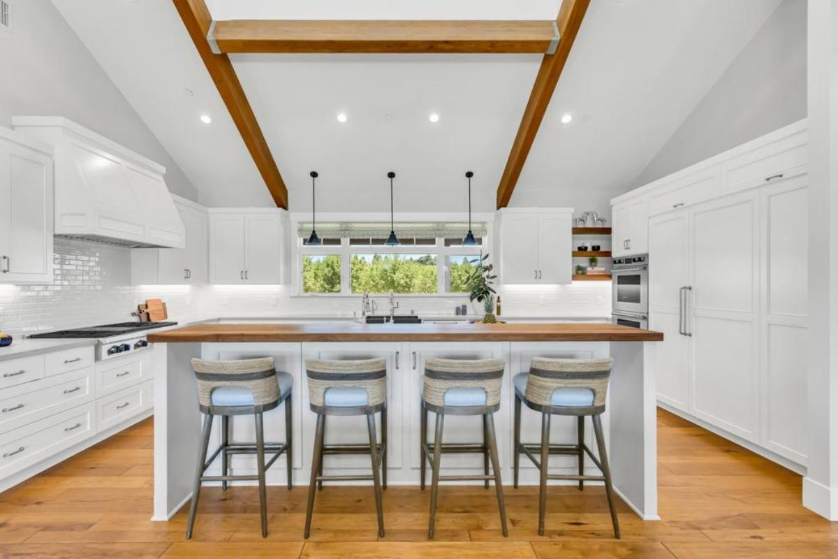 A kitchen featuring a bar with stools, countertops, and appliances.