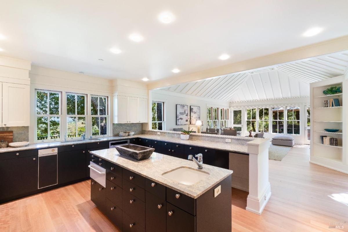 Kitchen with an island, granite countertops, and large windows.