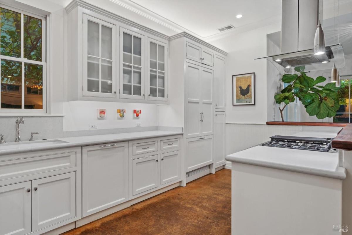 Kitchen with white cabinetry, a double oven, and stainless steel appliances.