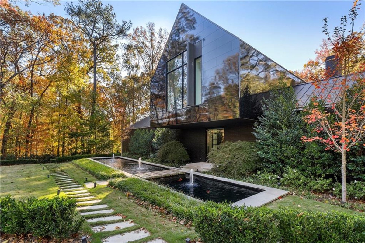 Angular architecture surrounded by autumn hues, reflecting elegance alongside serene water features.