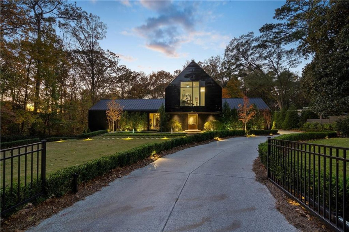 Striking facade illuminates under twilight, creating a seamless blend of modern design.