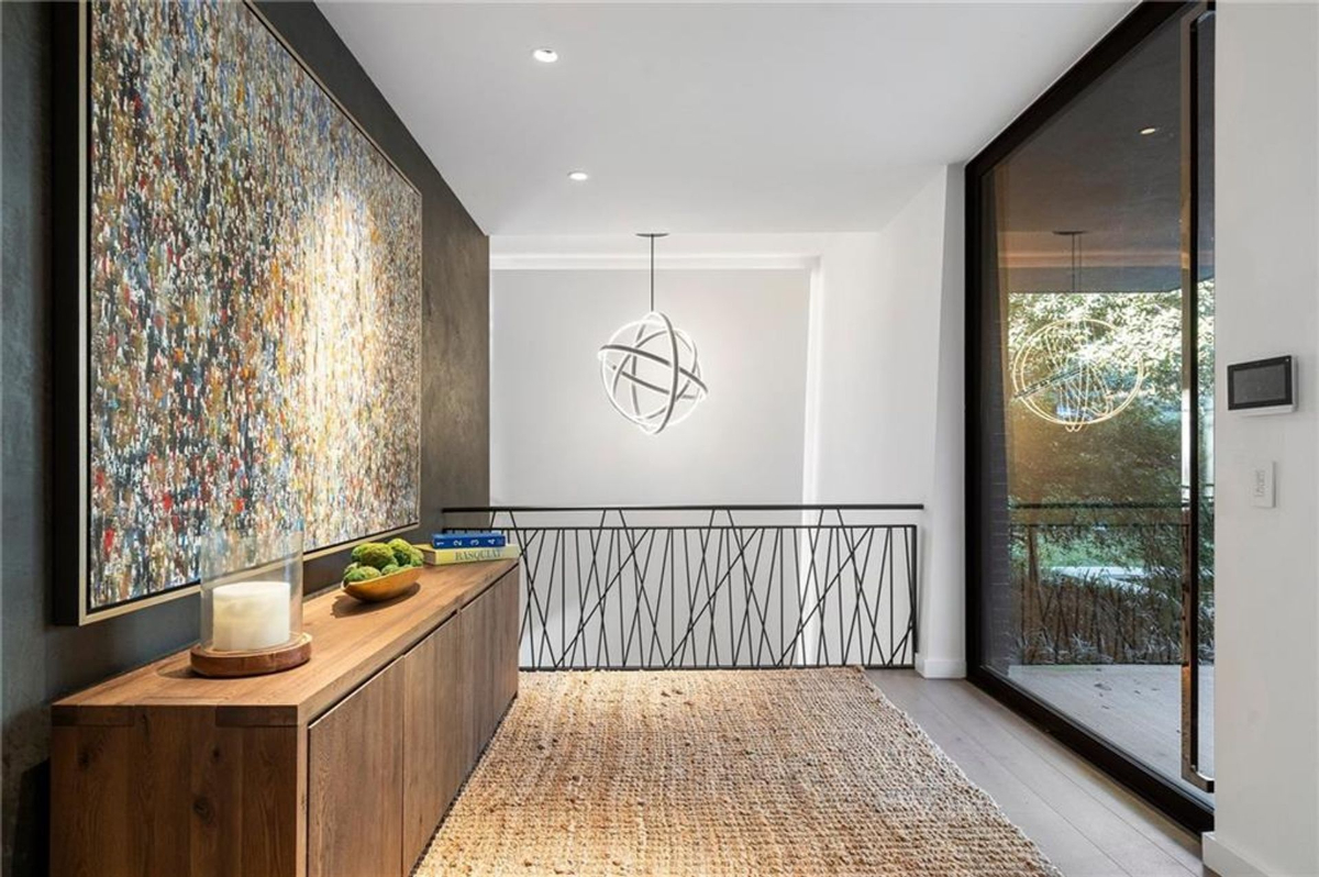 Hallway with a textured accent wall and abstract artwork.