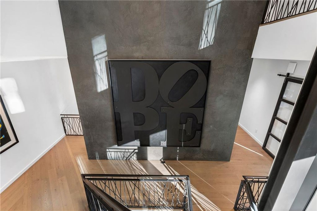 A bold "DOPE" art piece commands attention against a sleek textured wall in this stylish and modern stairway landing.