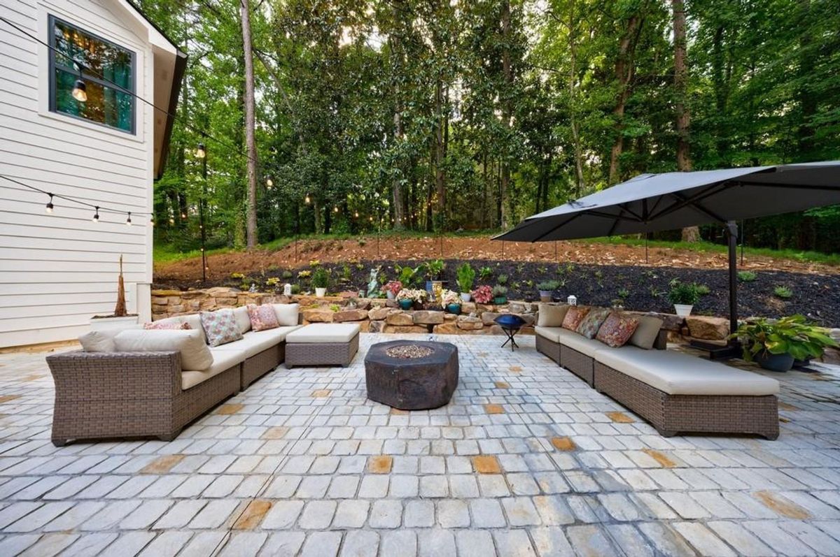 Outdoor seating area features modular sofas surrounding a fire pit, creating a comfortable and inviting space for gatherings.