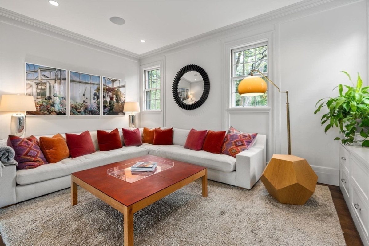 Family room with a vibrant sectional, modern art, and natural light creates a warm and inviting ambiance.