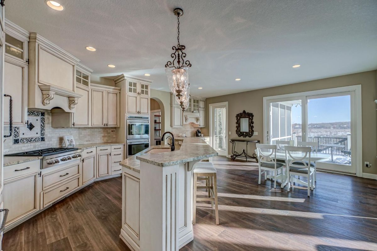 Kitchen boasts custom cabinetry, a central island, and elegant lighting.