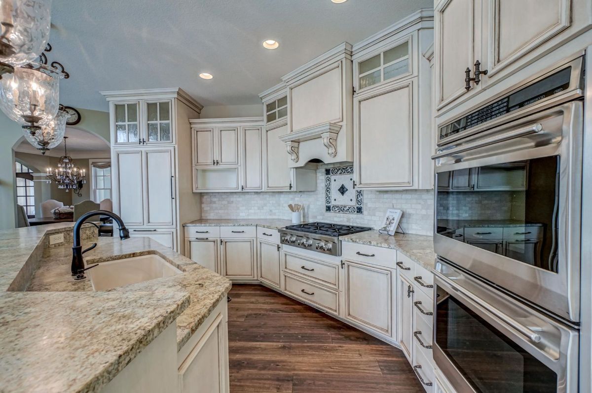 Kitchen features a stunning backsplash, built-in ovens, and ample counter space.