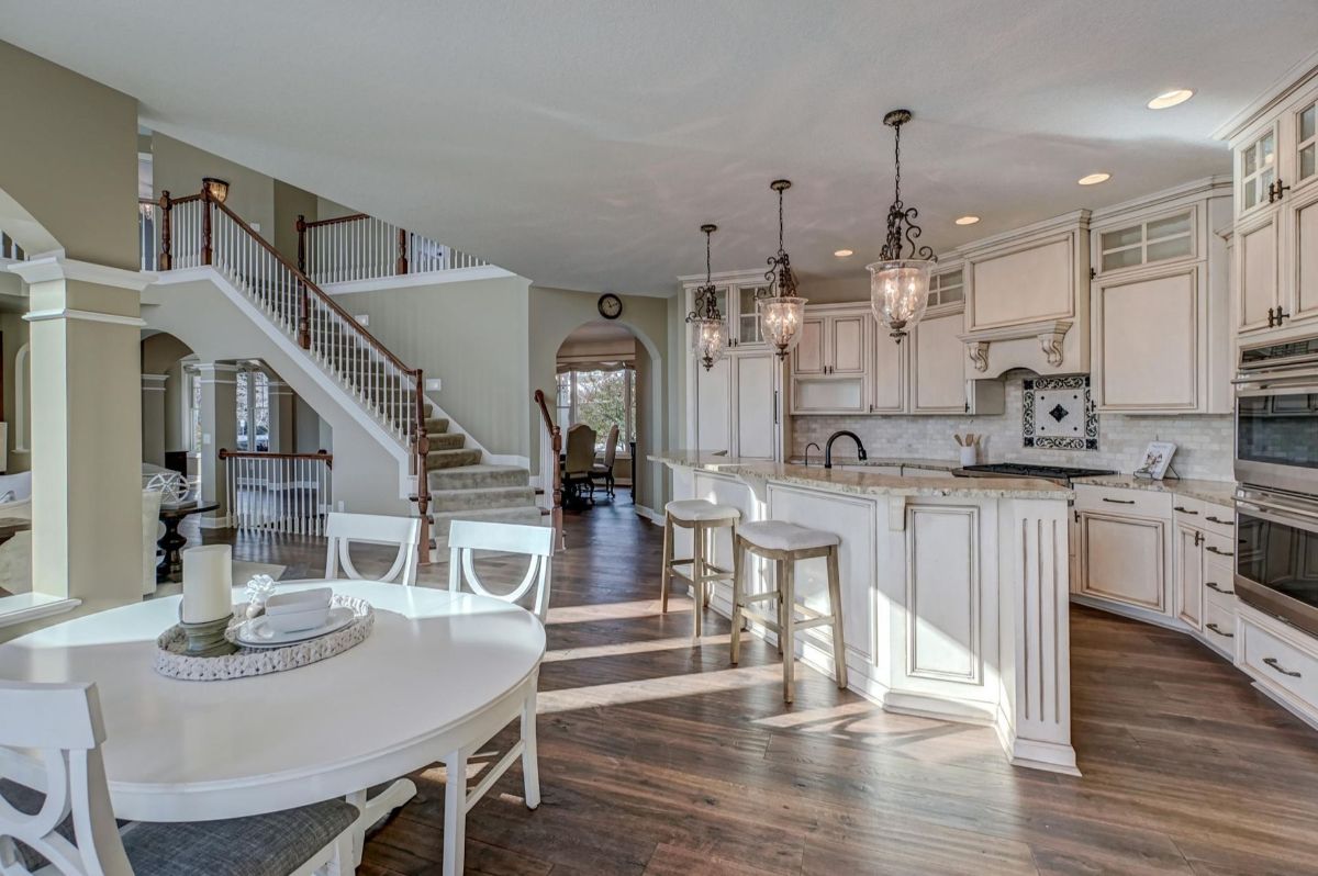 Bright open-concept kitchen and dining area with elegant chandeliers.