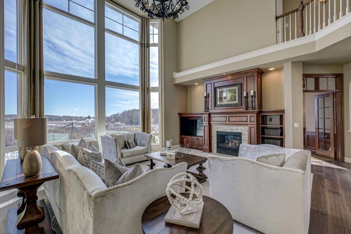 Grand living room with soaring windows and a cozy fireplace.