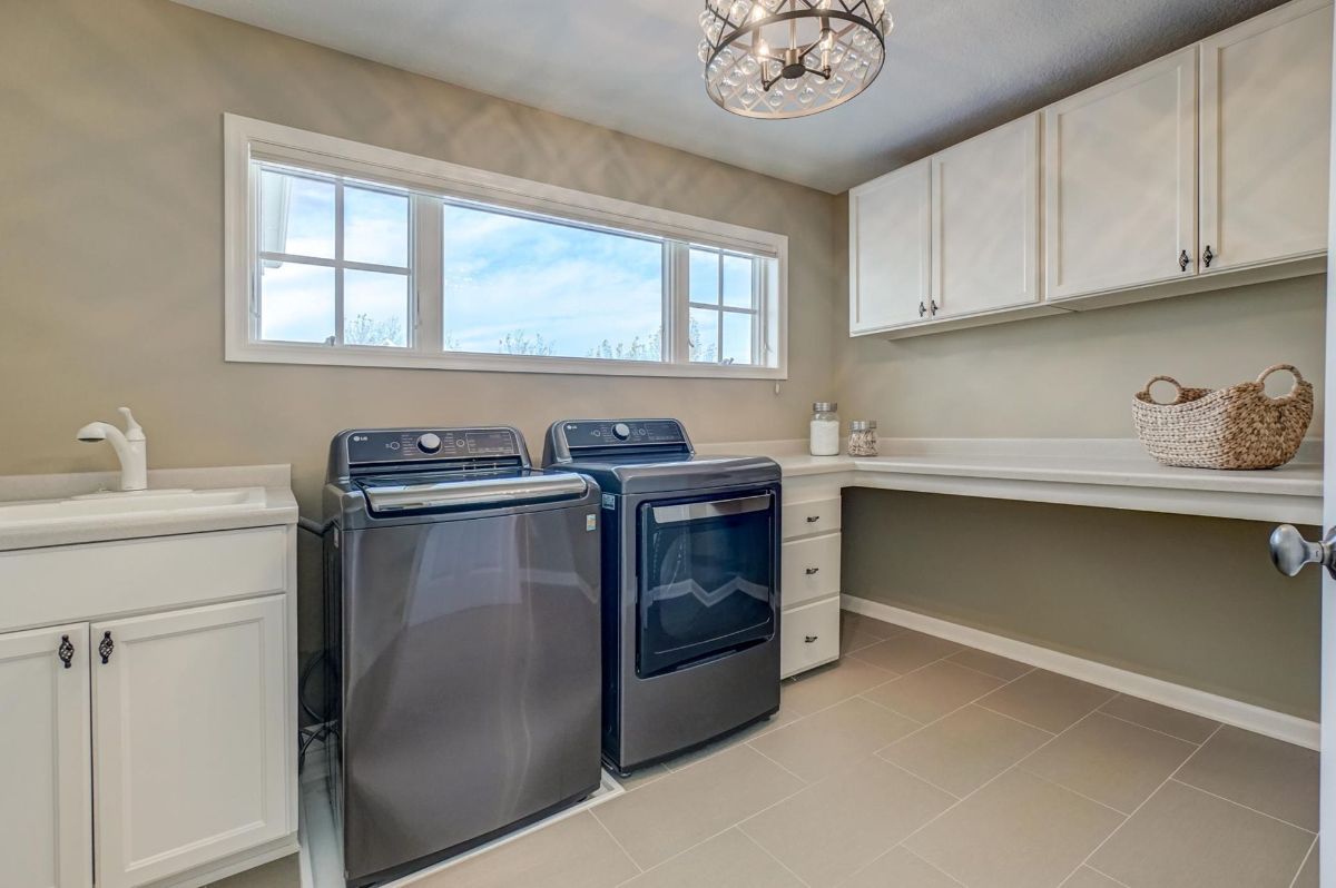 Bright laundry room with modern appliances, ample storage, and natural light.