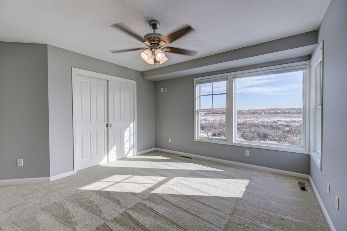 A bright and airy bedroom with large windows showcasing scenic views.