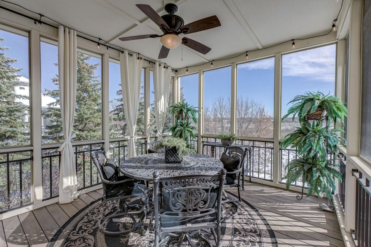 Screened-in porch with elegant furnishings and lush greenery.