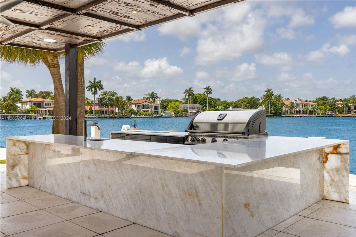 Outdoor marble kitchen offers a luxurious setting for waterfront dining and entertaining.