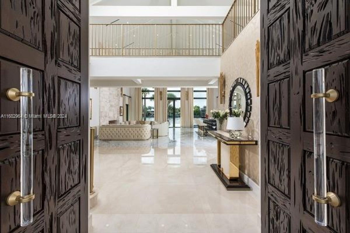 Entryway welcomes you with custom double doors and expansive views into a luxurious living space.