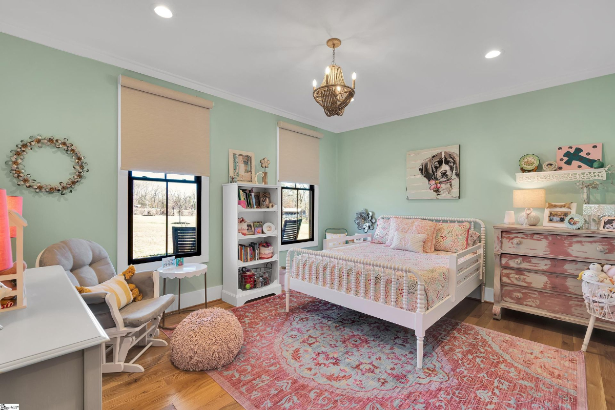 Charming bedroom featuring pastel green walls, vintage-inspired furniture, and playful decor accents.