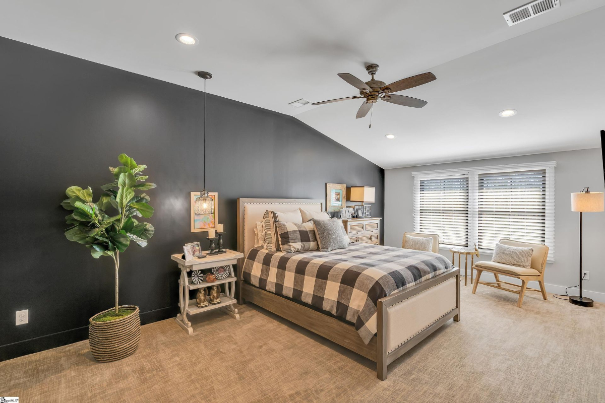 Contemporary bedroom with a striking black accent wall, cozy neutral tones, and stylish lighting details.