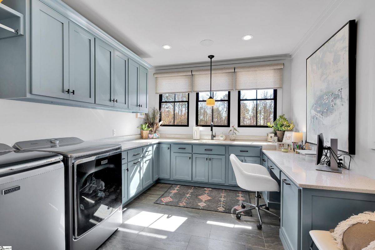 Stylish and functional laundry and craft room featuring blue cabinetry, ample countertop space.