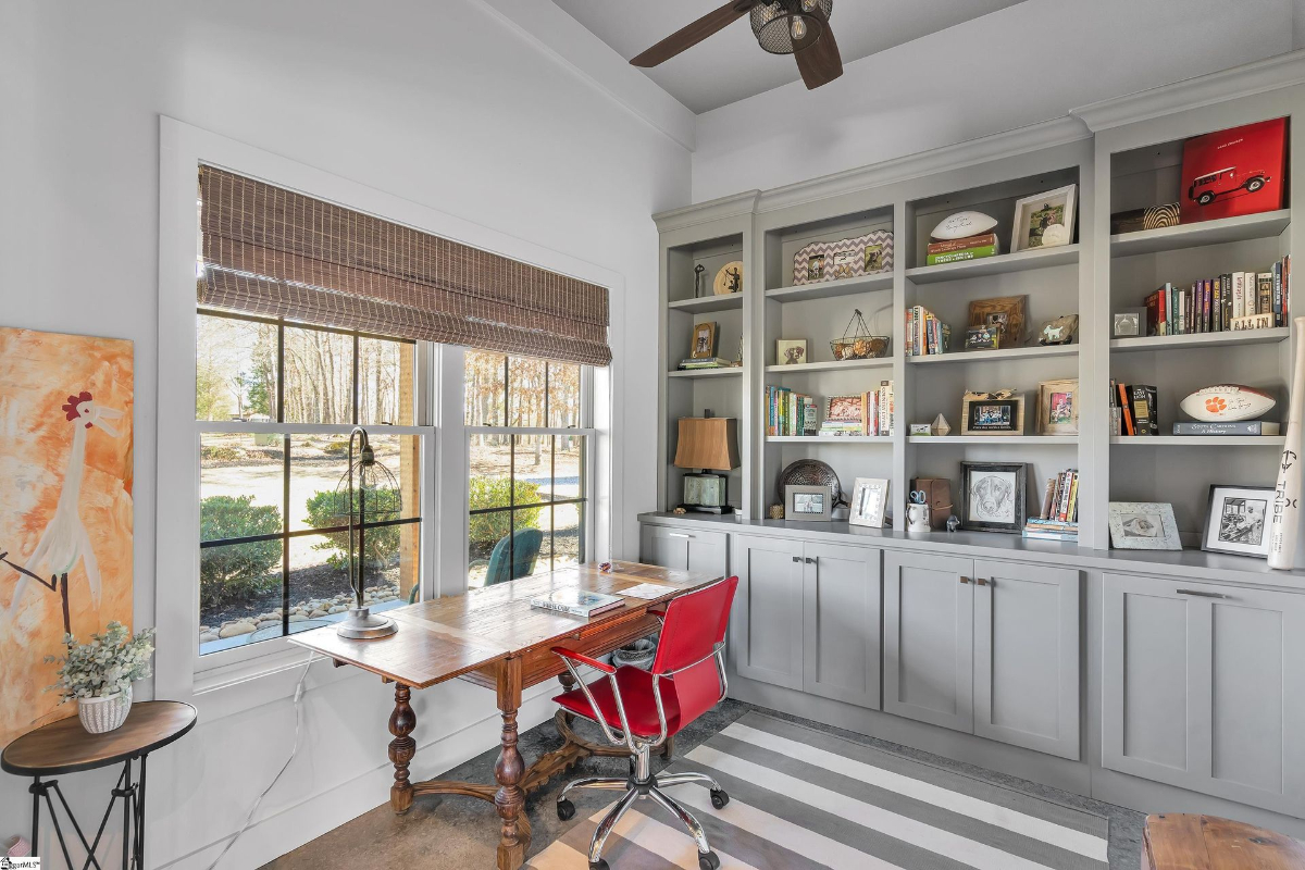 Bright home office showcasing custom built-in shelving and a picturesque window view.