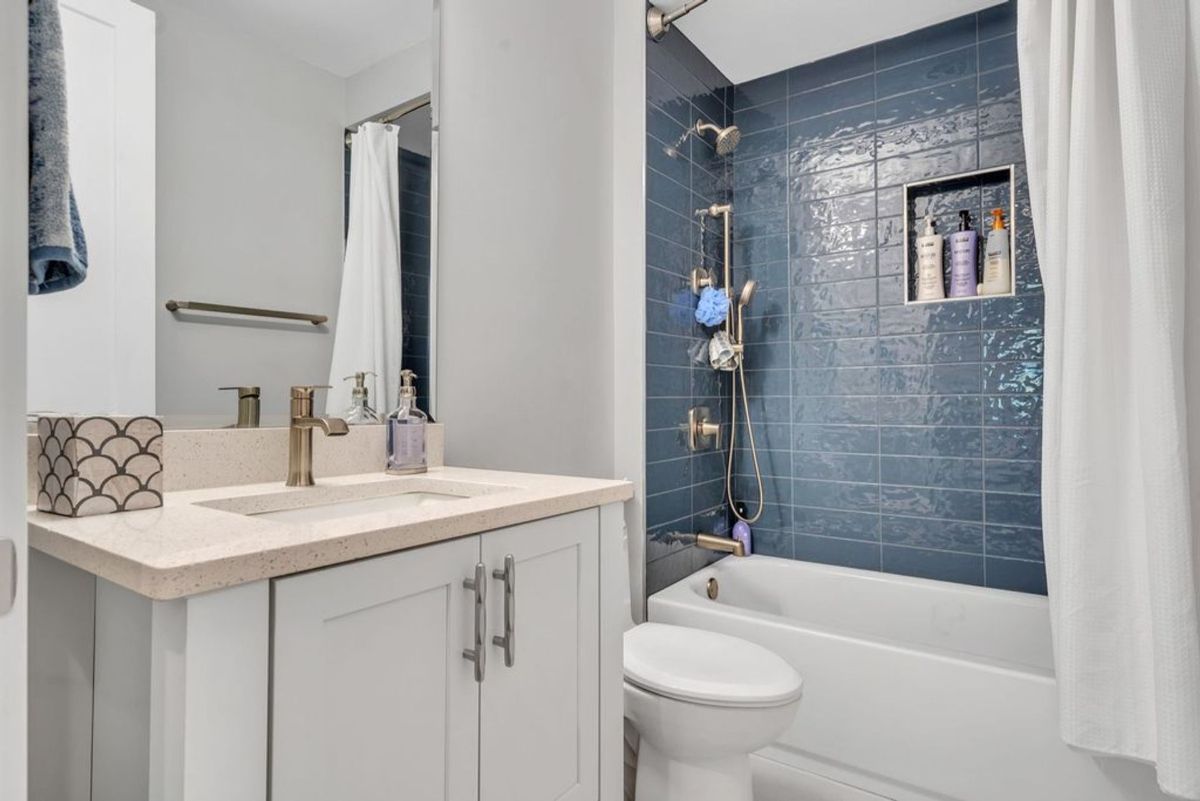 Bathroom features a sleek vanity and quartz countertop.